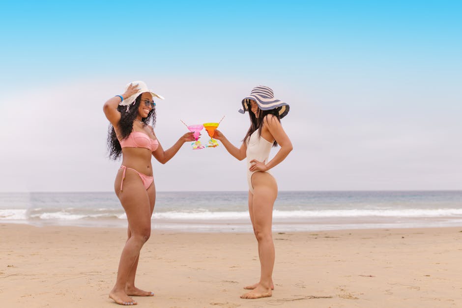 Deux amies en bikini sur la plage trinquant à l'été
